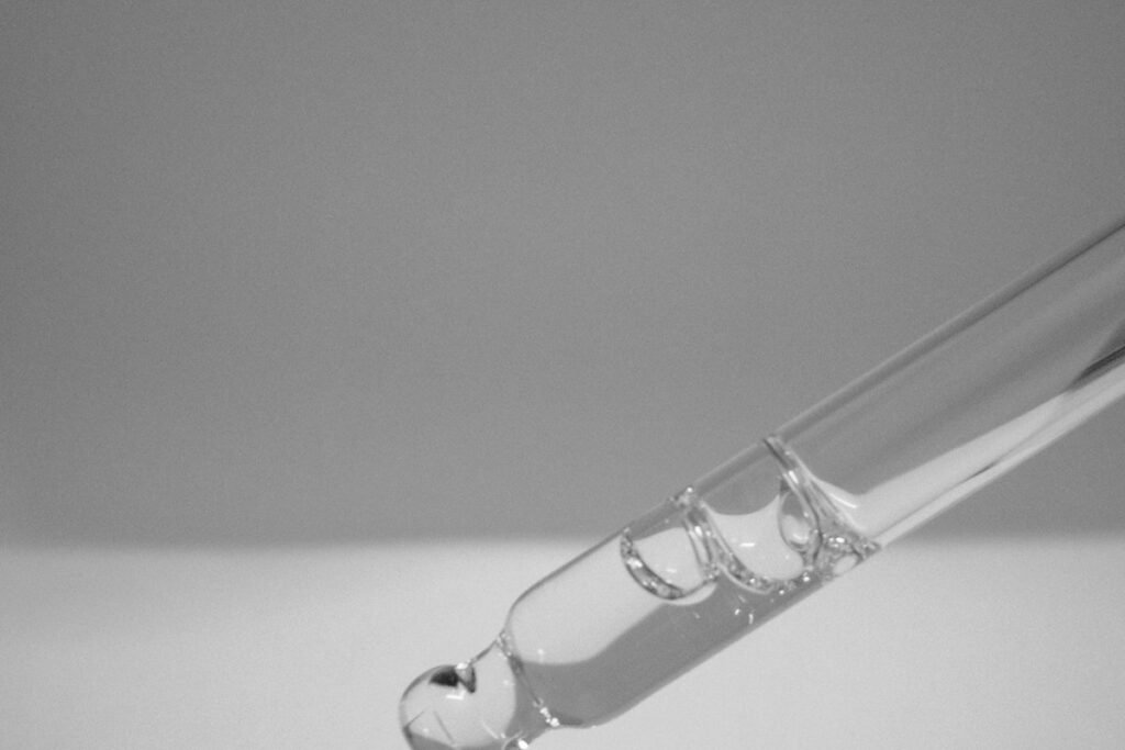 Serum dropper above a glass bottle
